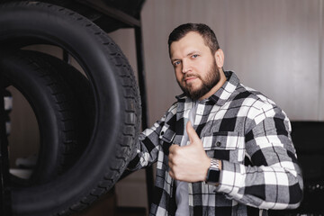 Caucasian adult male buy tires in garage shop with thumbs up gesture, tyre store