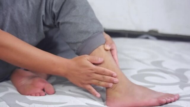 Close-up of a man massaging his ankle. Ankle pain, ankle injury. The concept of gentle post-traumatic care and self-touch as emotional and physical relief therapy.
