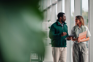 Diverse business colleagues discussing project walking in modern office