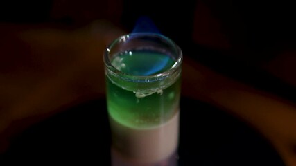 burns with a blue flame alcoholic drink Shot Bartender made some alcohol shots for guests close-up, cheers celebrate. Night bar with many varieties of cocktails and drinks. . High quality 4k