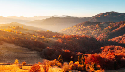 The golden hues of autumn paint the mountain slopes and the evening sun illuminates the hills creating an atmosphere of peace and harmony.