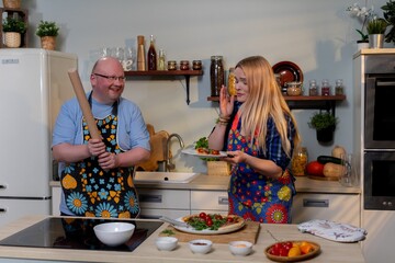 Couple making music while baking in cozy kitchen, Caucasian couple enjoying musical moment together while preparing breakfast in charming rustic kitchen setting