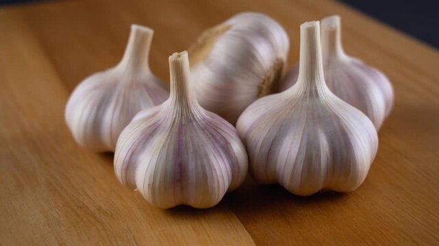 Close-up shot of garlic bulbs arranged on a wooden surface