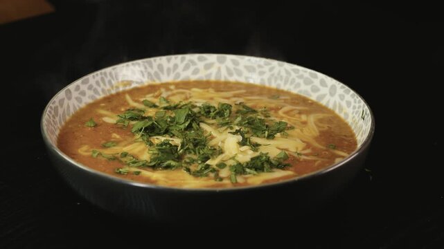 Thick vegetable soup with tender meat, melted cheese, and fresh parsley on top. Hearty, comforting, and perfect for cold days. Homemade and nutritious.