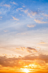 Sunset or sunrise sky with a vibrant gradient of orange, gold, and soft blue. Clear atmosphere with wispy clouds. Peaceful, natural light background. hope, freedom, new day Concepts, Vertical