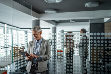 Senior businesswoman using digital tablet in modern office