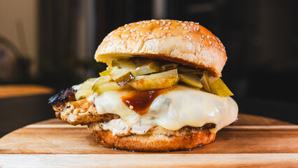 Succulent chicken breast burger on brioche bun with cheese, pickles, homemade mayo and barbecue...