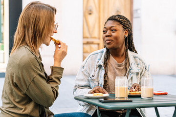 Diverse women friends enjoying lunch at outdoor cafe