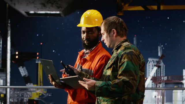 Soldier perform escort duty with walkie talkie on maritime vessel near offshore drilling rig, using radio communication to monitor operations and safeguard employees from security risks. Camera B.