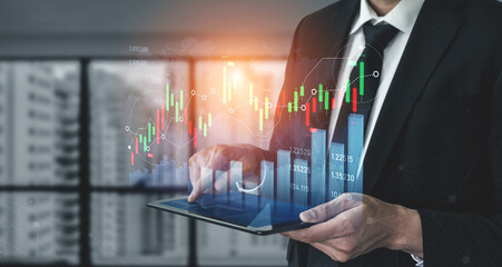 Businessman in formal attire engages with a digital tablet, analyzing stock market data and trends amidst a contemporary office environment, showcasing business growth potential. Scalp