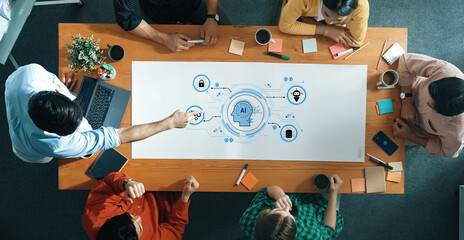 A high-angle view of a diverse group of professionals collaborating on an artificial intelligence project with a digital mind map on the table, showcasing innovation and teamwork dynamics. Trope