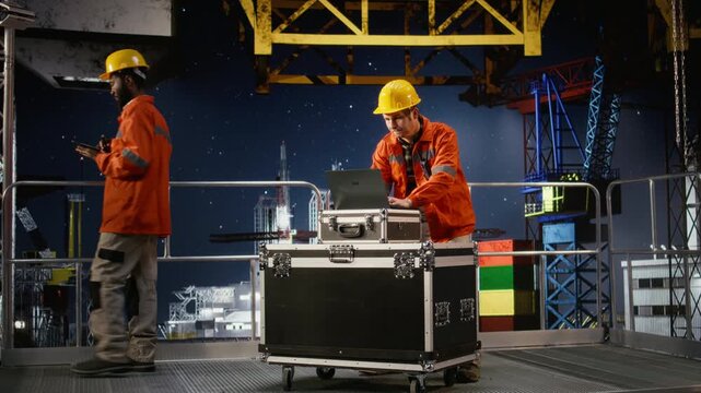 Concerned employee on offshore oil platform manages petroleum extraction using laptop, sweating and struggling to ensure safe oil extraction. Worried restless engineer. Camera A.