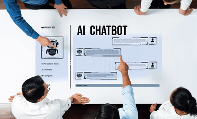 A diverse team collaborates around a modern table, discussing an AI chatbot design. Digital displays facilitate creative brainstorming and effective communication. Trope