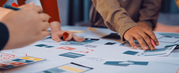 A dynamic brainstorming session captures diverse professionals collaborating on innovative design ideas. Colorful sketches and strategic planning are evident on the table. SACTR