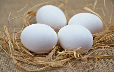 White eggs on jute and straw fabric. close-up white egg. horizontal view 