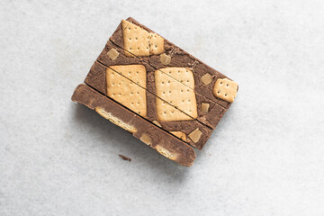 Overhead view of sliced chocolate fudge on marble countertop, top view of chocolate fudge topped with cookies and pieces of caramel chunks