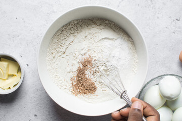 nigerian egg roll dough being mixed in a white bowl, process of making egg rolls