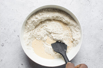 nigerian egg roll dough being mixed in a white bowl, process of making egg rolls