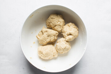 Overhead view of nigerian egg roll dough in a white bowl, overhead view of dough for making egg roll, process of making egg rolls