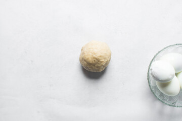 Egg being wrapped in dough to make nigerian egg roll, process of making nigerian egg roll and small chops