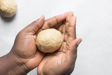 Egg being wrapped in dough to make nigerian egg roll, process of making nigerian egg roll and small chops