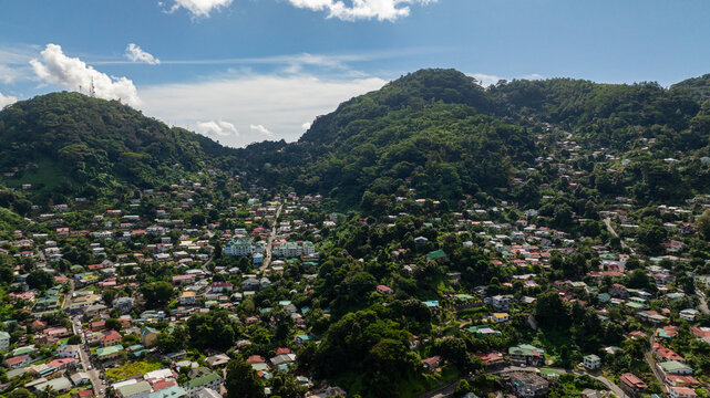 A densely populated residential area surrounded by green mountains and valleys. Victoria. Seychelles, Mahe. - Powered by Adobe