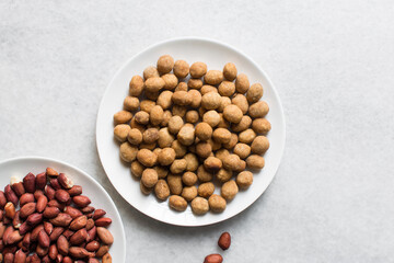 Overhead view of coated peanuts and cracker peanuts on a marble countertop, top view of nigerian peanut snack
