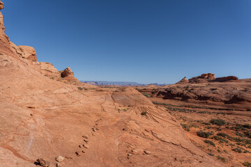 Fototapeta premium Beehive and New Wave trails in Glen Canyon National Recreation Area near Page, Arizona. Sandstone outcroppings, windswept rock formations, breathtaking views of desert landscape and distant mountains.