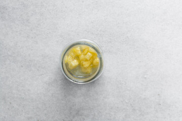 Overhead view of diced pineapple and sugar mixed together, process of making pineapple cheong or pineapple syrup
