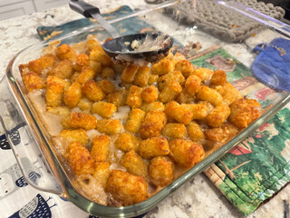 Tater tot hot dish, half eaten, homemade, sitting on the counter in the kitchen