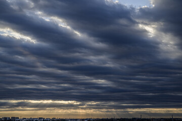 まだら雲の天空から地平線に降り注ぐ朝の光