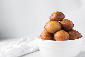 close up view of nigerian puff-puff on a white plate, nigerian fried dough balls, homemade bofrot on a white background