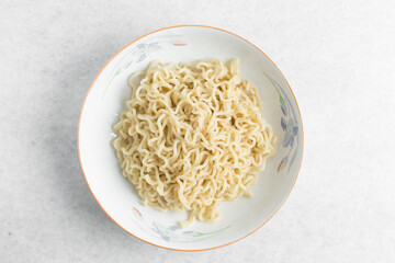 Overhead view of plain ramen noodles in a white bowl