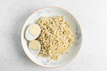 Overhead view of plain ramen noodles in a white bowl