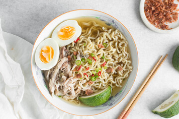 Overhead view of noodles in clear broth with hard boiled eggs