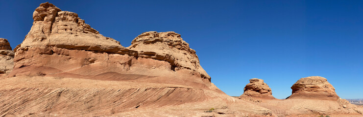Fototapeta premium Beehive and New Wave trails in Glen Canyon National Recreation Area near Page, Arizona. Sandstone outcroppings, windswept rock formations, breathtaking views of desert landscape and distant mountains.
