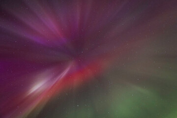 Aurora Blast Over Night Sky With Purple Green Streaks and Distant Stars