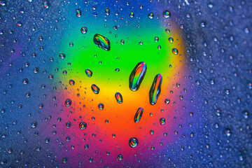 AI generated droplets reflecting neon spectral light over a vibrant rainbow background creating a surreal abstract scene filled with depth color brilliance and futuristic energy