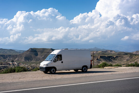 Camper van traveling through Tabernas Desert landscape in Andalusia, Spain