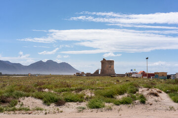 Cabo de Gata coastal landscape featuring ancient tower and mountains in Spain