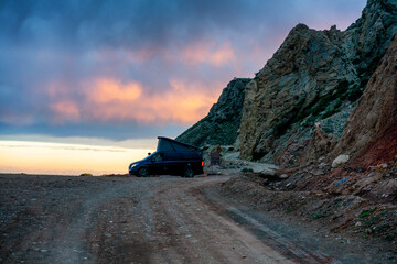 Camper van parked on a dirt road by the coast enjoying a beautiful sunset in the south of Spain