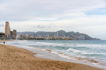 Benidorm beach with hotels on a cloudy day, in Spain