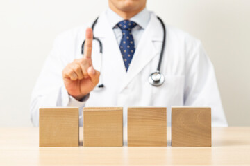 説明をする医師と無地のブロック