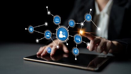 A focused view of a hand touching a tablet screen, showcasing digital connections and networking symbols that reflect technology integration in a modern workspace. Tessel