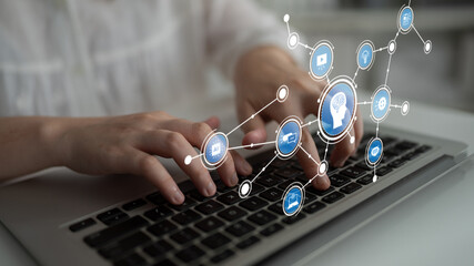 Close-up of hands typing on a laptop, surrounded by digital icons that symbolize technology and innovation, showcasing the importance of connectivity in modern work environments. Tessel
