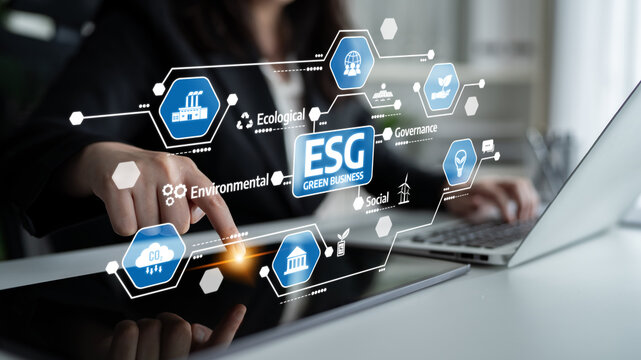 A business professional interacts with digital ESG concepts displayed on a tablet, highlighting the importance of sustainability in modern corporate strategies. Tessel - Powered by Adobe