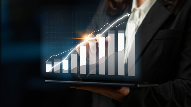 A business professional showcases a data visualization of a rising growth chart on a tablet, highlighting trends and success in a modern corporate setting. Impute - Powered by Adobe