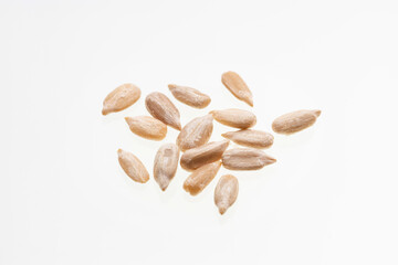 Helianthus annuus - Pile of hulled sunflower seeds on a white background