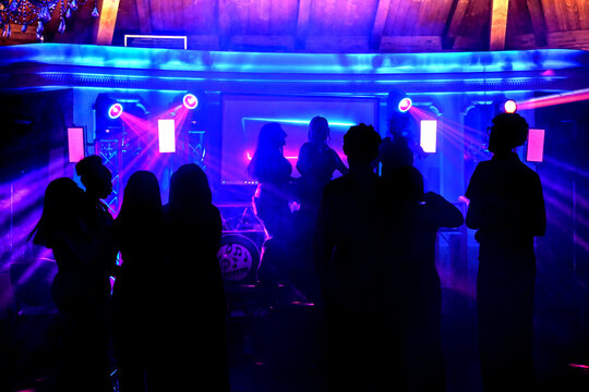 ragazzi ballano in una discoteca illuminati dai faretti