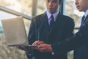 New employee working with laptop, training has been guided and consulting by colleagues. Selected...